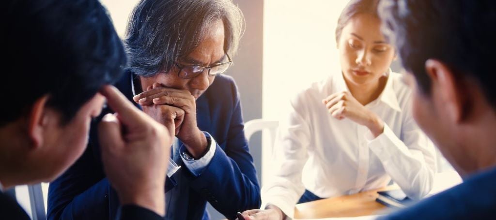 Stressed business team gathered around desk