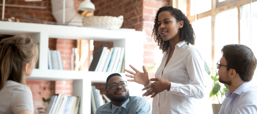 Black Businesswoman stands and presents idea at a meeting